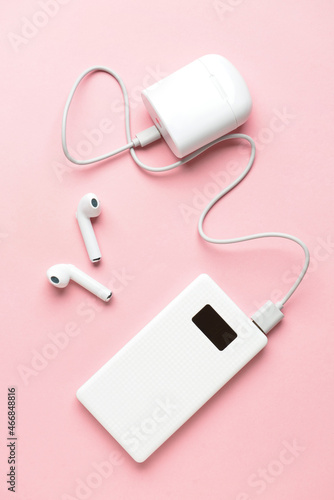 Modern power bank and case for earphones on pink background