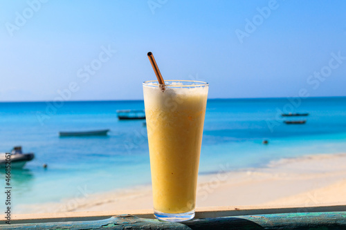 Glass of fresh juice by the ocean. Tropical vacations concept