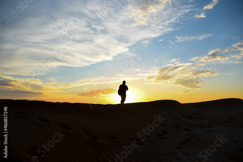 A man walks on the sand against the sky. © Natalya Temnaya
