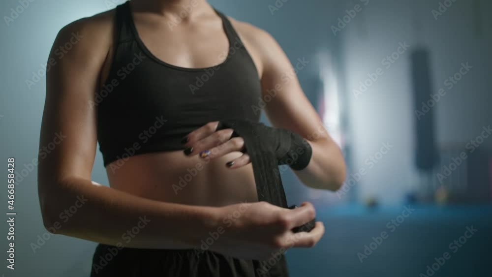 Female fighter wraps her hands with boxing bandages, kickboxing training day in a gym, female fighter is preparing for battle, 4k slow motion. Female fighter wraps her hands with boxing bandages, kickboxing training day in a gym, female fighter is preparing for battle, 4k slow motion.