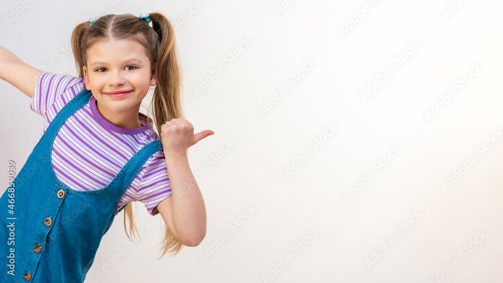 A little girl points her hand at the advertisement. White isolated background. A little girl points her hand at the advertisement. White isolated background.