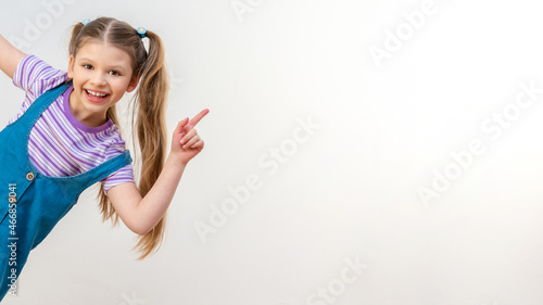 Bild auf Leinwand A little girl points her hand at the advertisement