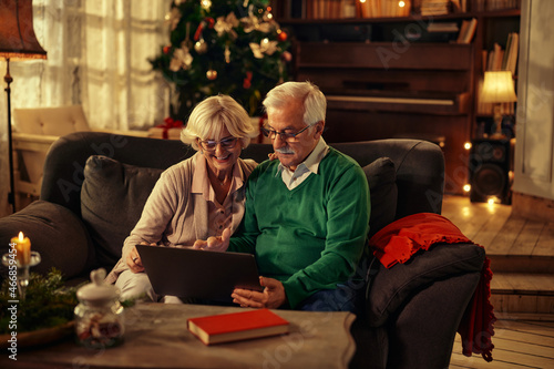 Senior couple having video call via laptop at Christmas morning