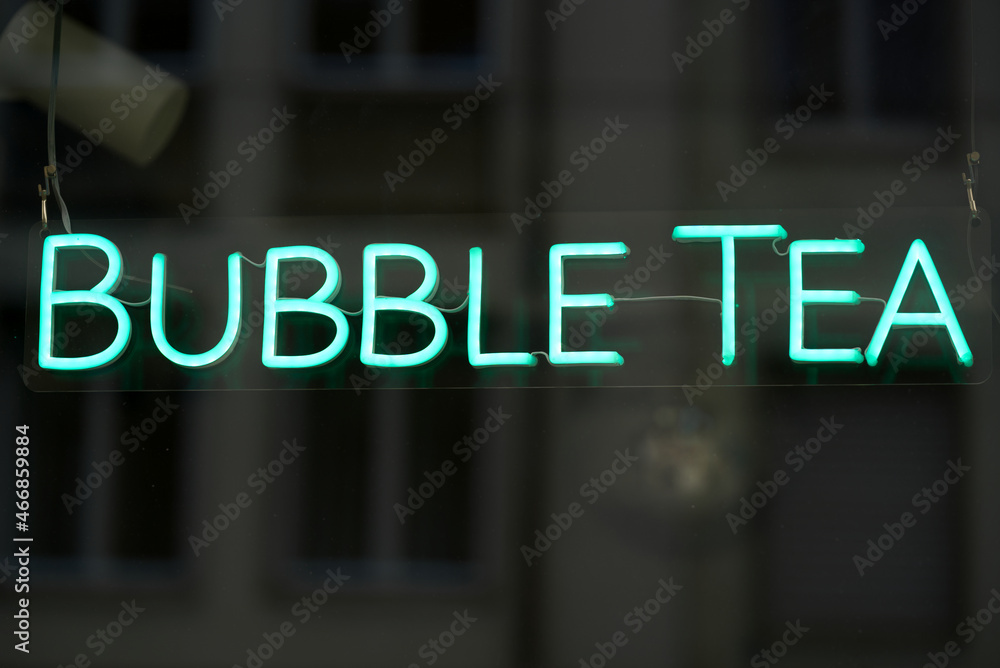Light green neon text bubble tea at shopping window at downtown Zürich on a cloudy day. Photo taken October 12th, 2021, Zurich, Switzerland.