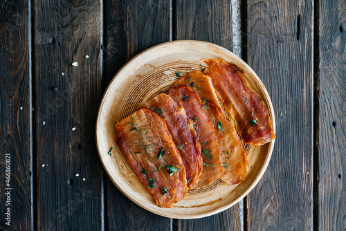 Dried chicken, dried poultry, cut into strips on a plate on a wooden background. High quality photo