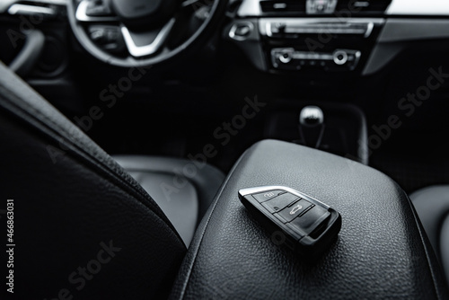 Car key remote in black leather interior. Start engine key.