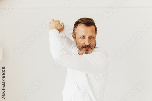 фотографія Senior man doing stretching exercises with his arms