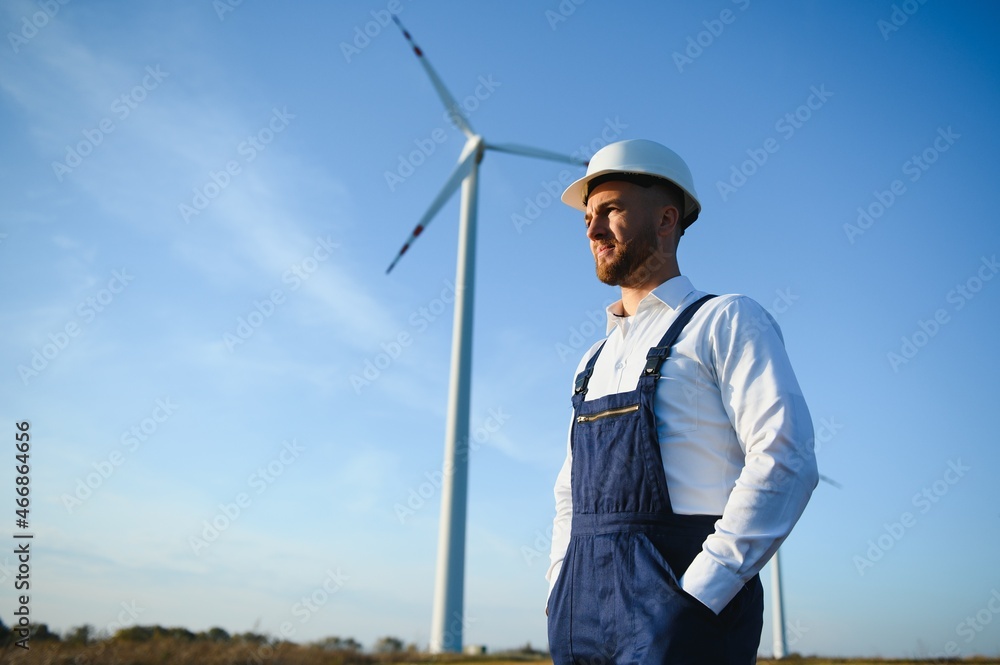 Engineer in wheat field checking on turbine production Engineer in wheat field checking on turbine production