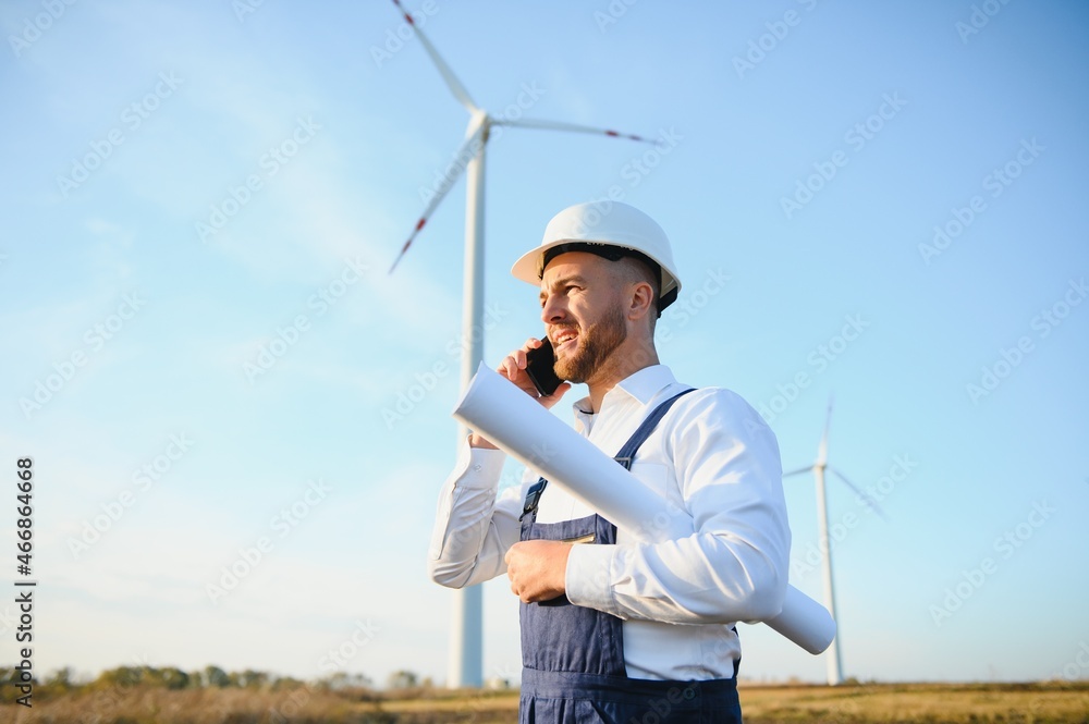 Young Businessman Talking to Manager Using Smart Telephone On Wind Turbine Field, Green Energy Concept Young Businessman Talking to Manager Using Smart Telephone On Wind Turbine Field, Green Energy Concept