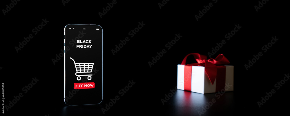 Online shopping gifts. Black Friday banner with internet shopping app on mobile phone, white gifts with red bow falling on black background. Present online concept. Online shopping gifts. Black Friday banner with internet shopping app on mobile phone, white gifts with red bow falling on black background. Present online concept.