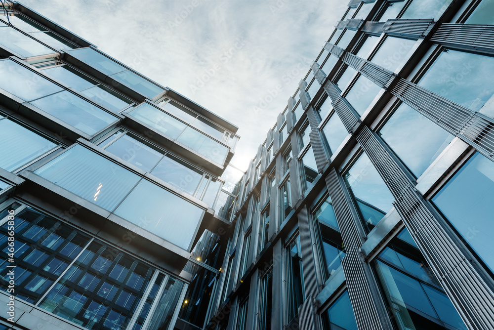 Obraz premium Looking Up Blue Modern Office Building. Background of Modern Glass Building Skyscrapers