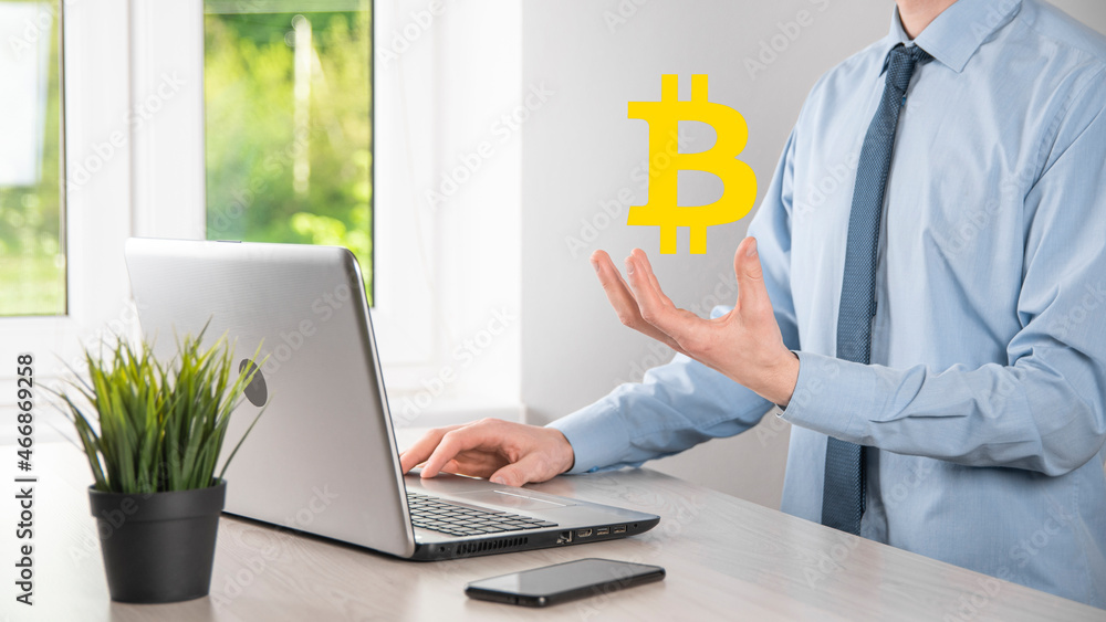 Male hand holding a bitcoin icon on blue background. Bitcoin Cryptocurrency Digital Bit Coin BTC Currency Technology Business Internet Concept.