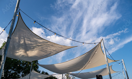 Canvas shade canopies against a blue sky.