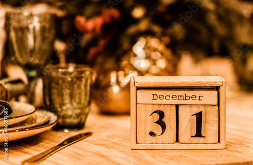Photography wooden calendar with date of 31 december stands on the table against the backgro