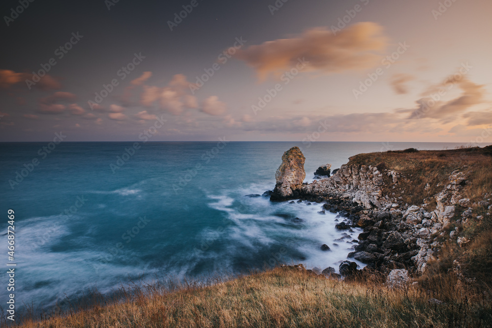 Long Exposure Landscape by the sea with beach with Crashing Waves and Rocks