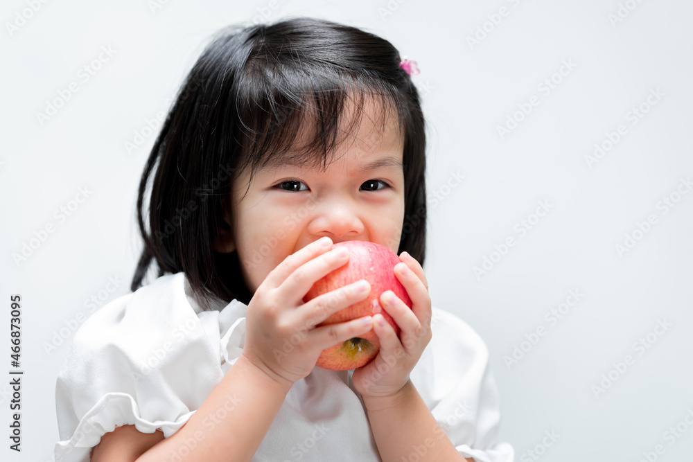 Little child was eating a red apple with gusto. Isolated white background. Little child was eating a red apple with gusto. Isolated white background.