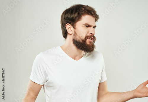 emotional man in a white t-shirt hand gestures anger close-up