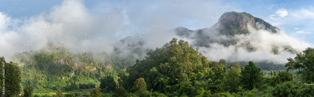 Scenic early morning rural landscape panorama with low clouds above valley and limestone mountain, Chiang Dao countryside, Chiang Mai, Thailand