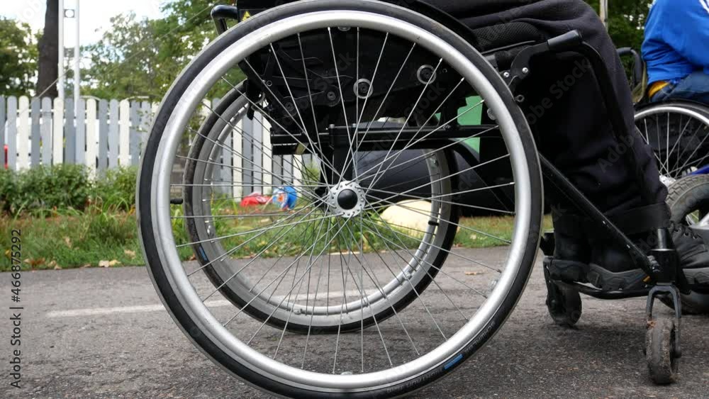 Wheelchair wheels close up. A person's movement in the city in a wheelchair Wheelchair wheels close up. A person's movement in the city in a wheelchair