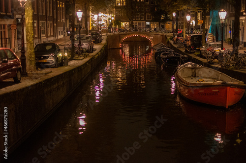 Gracht in Amsterdam, mit Booten und Brücke, am Abend