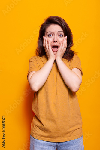 Billede på lærred Portrait of horrified woman having hands on face and mouth open to pose on camera