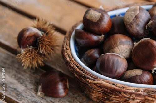 basket full of fresh chestnuts on wooden background