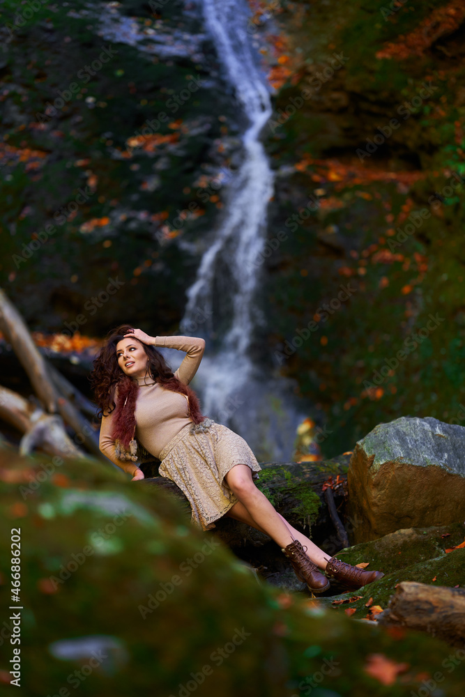 Beautiful young woman by a waterfall Beautiful young woman by a waterfall