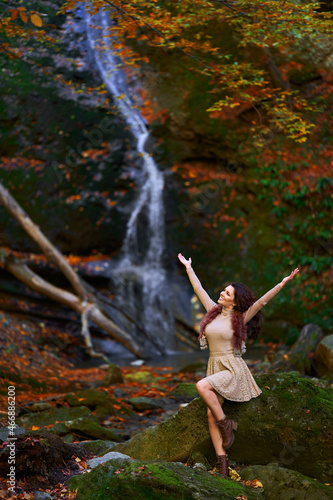 Beautiful young woman by a waterfall