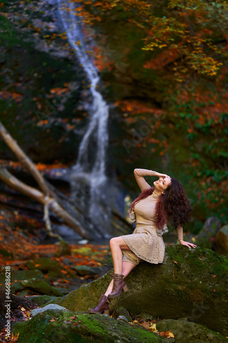 Beautiful young woman by a waterfall