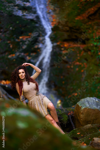Fototapeta Naklejka Na Ścianę i Meble -  Beautiful young woman by a waterfall