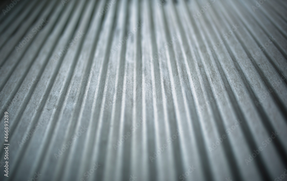 strong lighting and contrast on lines formed on a silver rustic metal fence outdoors, in the backyard strong lighting and contrast on lines formed on a silver rustic metal fence outdoors, in the backyard