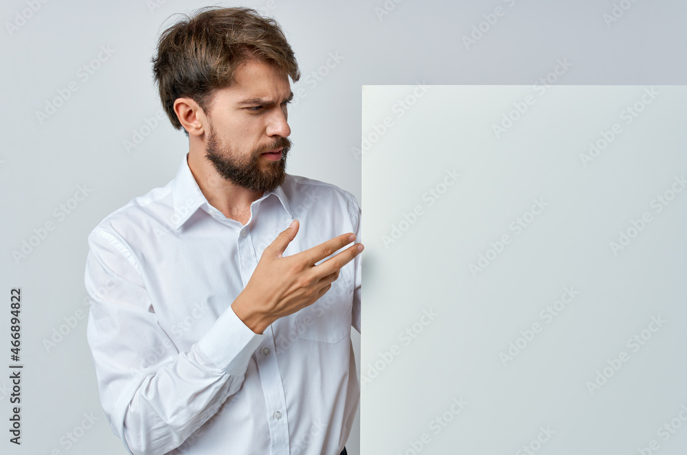 Cheerful man white banner in hand blank sheet presentation isolated background Cheerful man white banner in hand blank sheet presentation isolated background