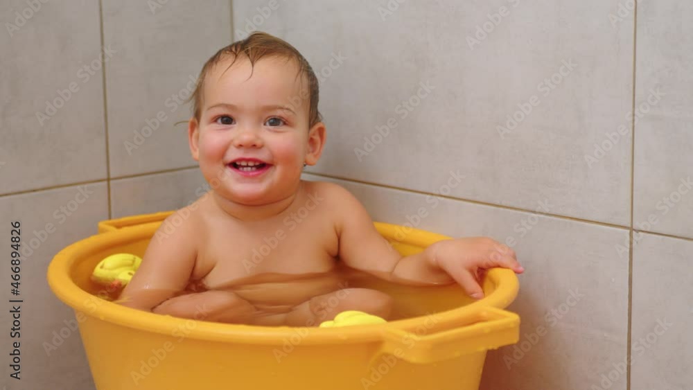 Slow motion video of adorable baby girl sitting and smiling at bath. Slow motion video of adorable baby girl sitting and smiling at bath.