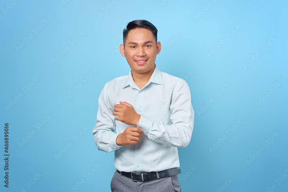Young handsome businessman holding hands with confident face on blue background Young handsome businessman holding hands with confident face on blue background