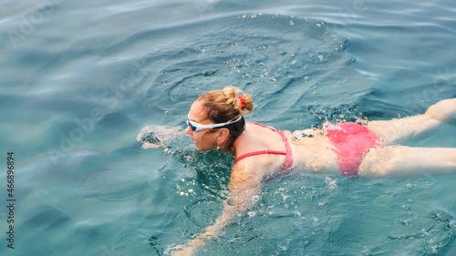 female senora in glasses is practicing crawl swimming in the sea. Professional swimmer, swimming race. Front crawl swimmer. Swimming lessons. © Евгения Медведева