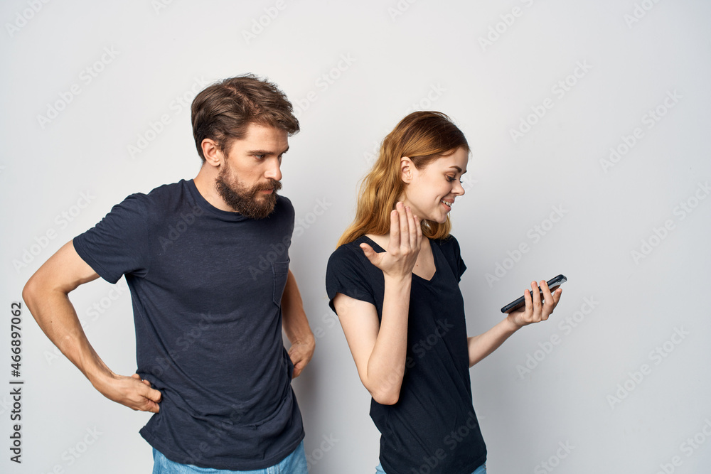 Fototapeta premium cheerful young couple with a phone in hand emotions Studio Lifestyle