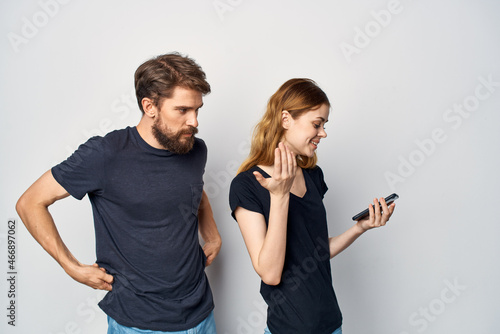 cheerful young couple with a phone in hand emotions Studio Lifestyle