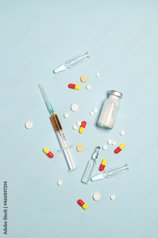 Drugs heroin powder pill and syringes on blue background Drugs heroin powder pill and syringes on blue background