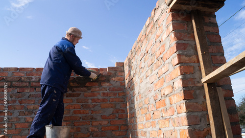 Wallpaper Mural bricklayer lays bricks on scaffolding Torontodigital.ca