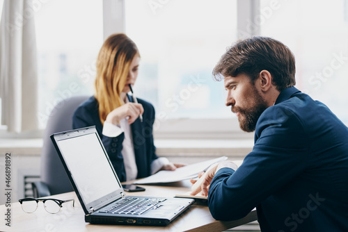 managers sitting at a desk with a laptop communication finance technologies