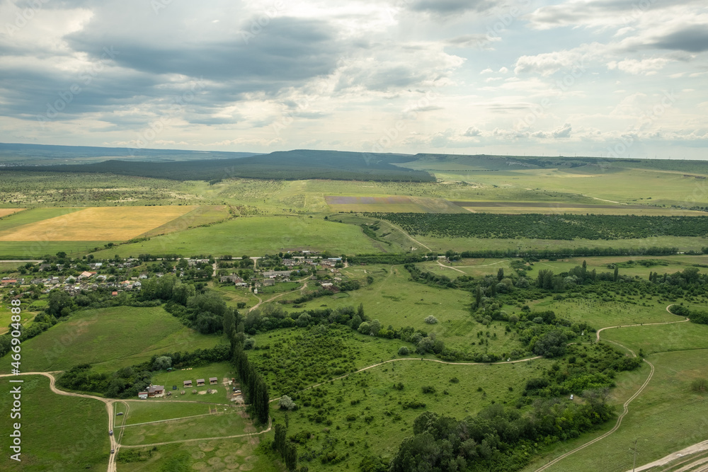 Panorama of the steppe landscape. View from the mountain to the surrounding area. Fields, roads, villages, mountains from a bird's eye view. Day. Summer