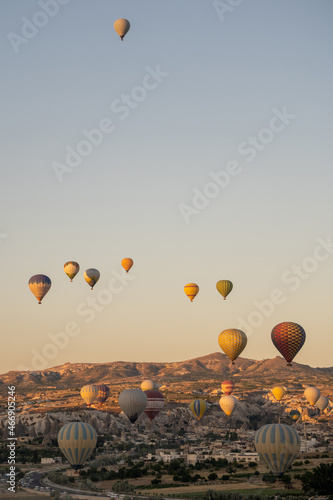 Vertical photo of beautiful panoramic nature landscape of countryside mountains with colorful high hot air balloons in summer sky. Vacation travel panorama background