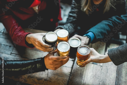 Canvas Print Young group of people having fun cheering with beer outdoor at bar restaurant -