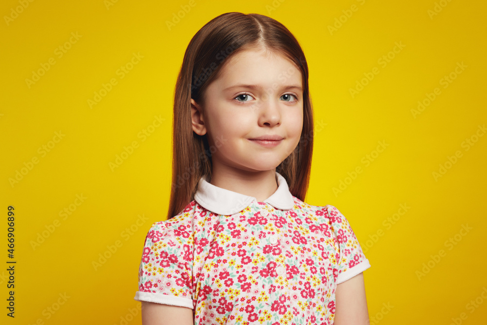 Close up photo of beautiful schoolgirl in casual summer clothes, looking at camera with happy expression, isolated over yellow background Close up photo of beautiful schoolgirl in casual summer clothes, looking at camera with happy expression, isolated over yellow background