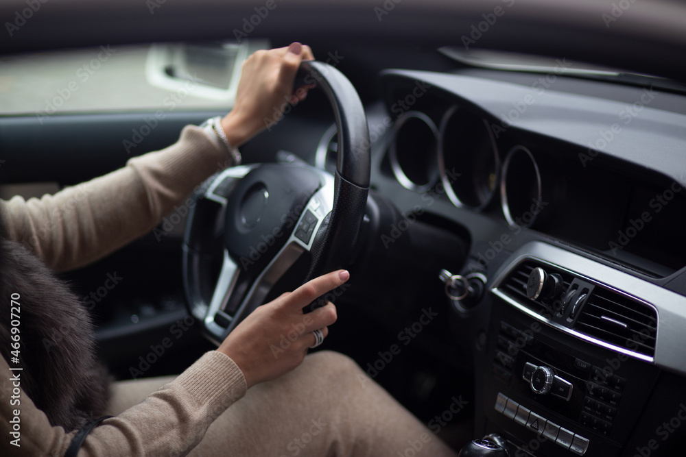 woman's hands on the steering wheel in the car