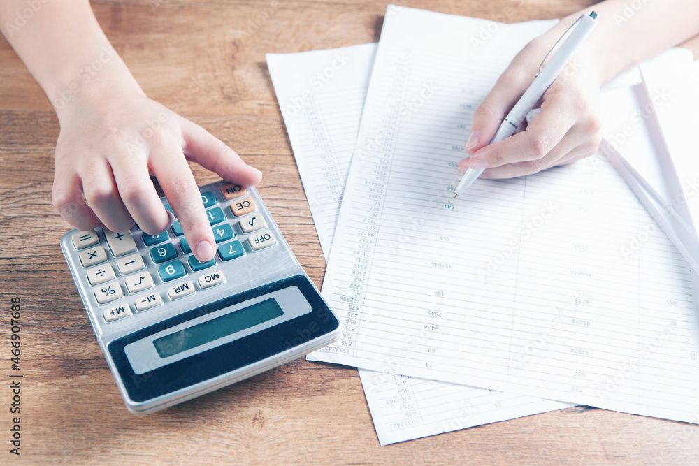 young woman counting on a calculator young woman counting on a calculator