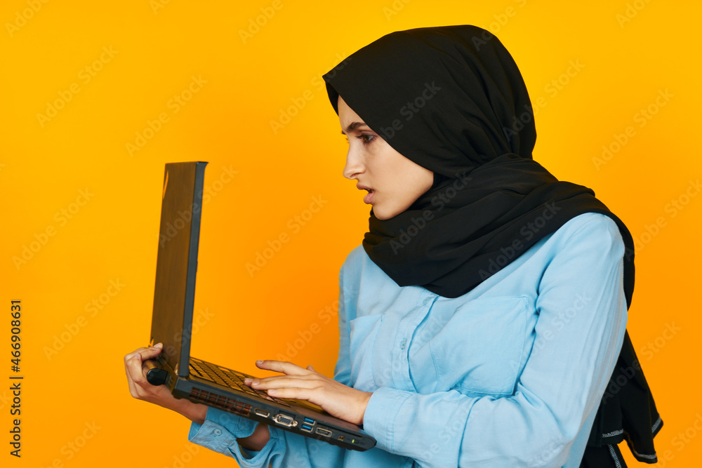 Muslim with laptop in hands technology emotions yellow background Muslim with laptop in hands technology emotions yellow background