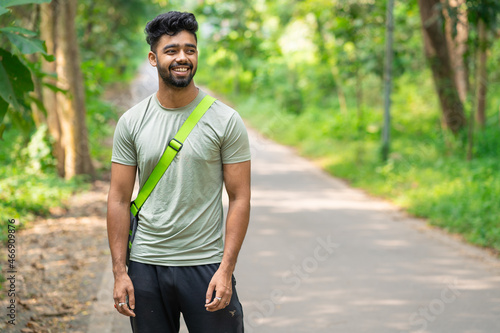 Young cheerful man holding fitness sports bag.