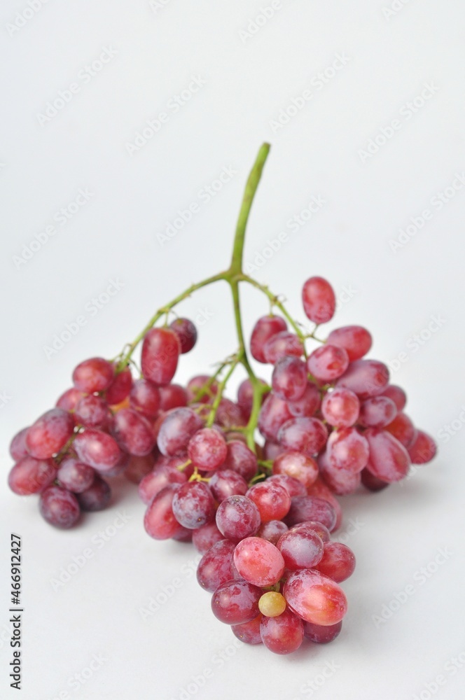 Fototapeta premium bunch of fresh seedless red grapes isolated on white background.