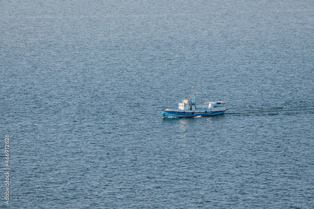 Naklejka premium Ferry boat or fishing ship transporting passengers on Lake Sevan in Armenia. Water cruise and tours concept